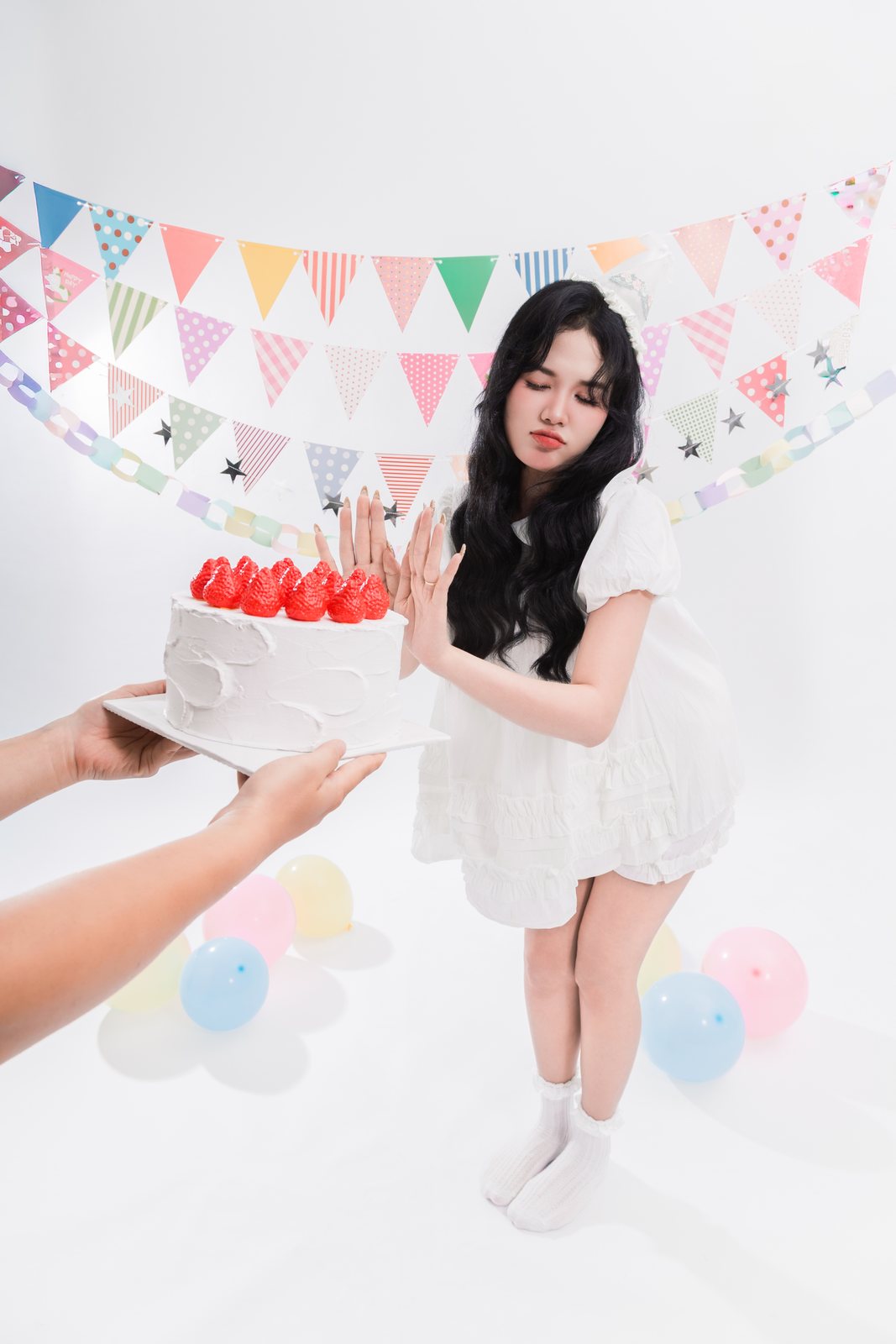 Cô gái chắp tay trước bánh sinh nhật